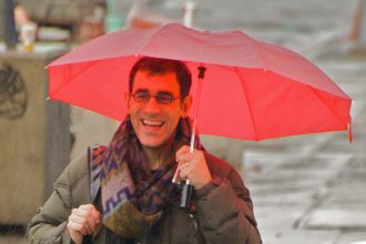 People with umbrellas crossing a rainy city street
