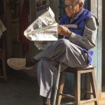 A person reading the morning news on a phone with coffee