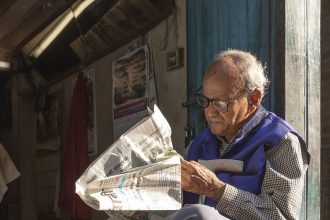 A person reading the morning news on a phone with coffee