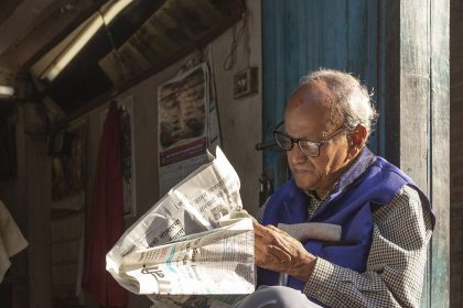 A person reading the morning news on a phone with coffee