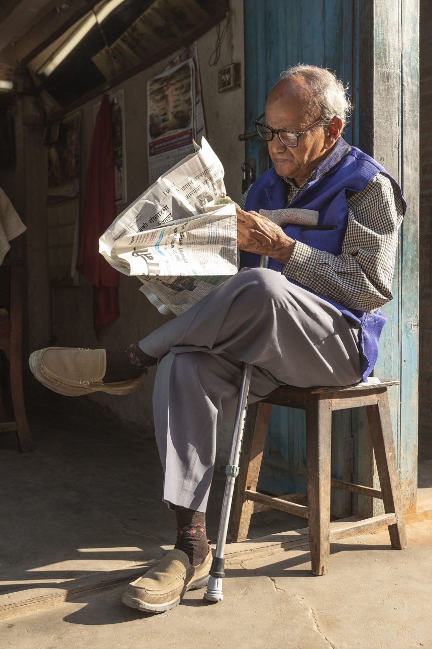 A person reading the morning news on a phone with coffee