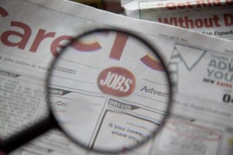 Newspapers being examined closely with a magnifying glass