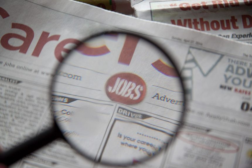 Newspapers being examined closely with a magnifying glass
